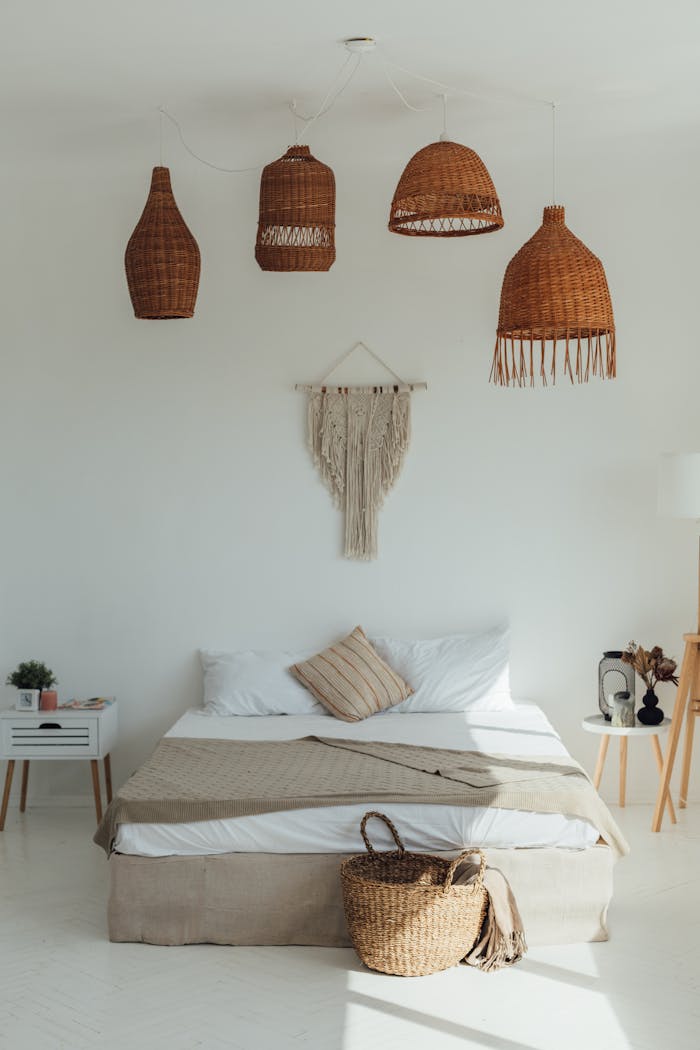 Boutique bedroom with wicker decor, macrame art, and a cozy modern design in neutral tones.